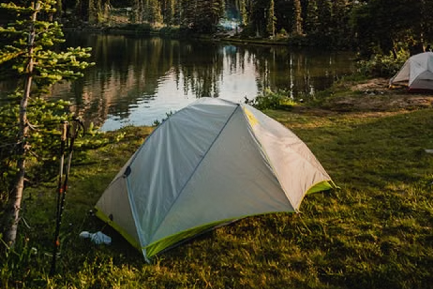 Tent bij wandelstokken aan het water